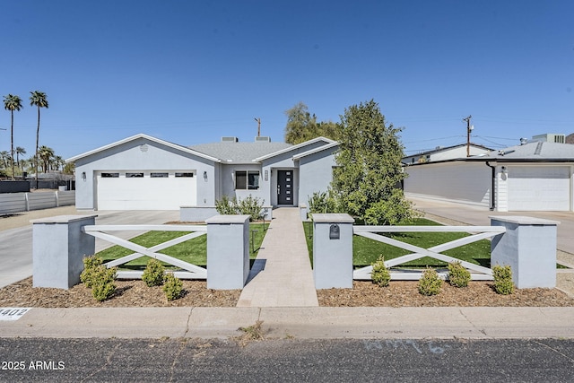 view of front of house featuring a fenced front yard, stucco siding, an attached garage, and concrete driveway