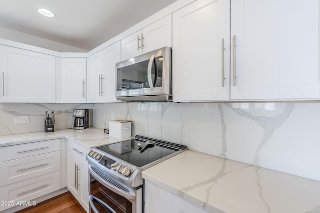 kitchen featuring white cabinetry, light stone counters, tasteful backsplash, and appliances with stainless steel finishes