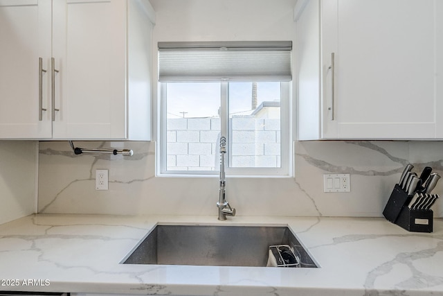 kitchen with a sink, plenty of natural light, and white cabinets