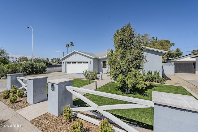 view of front of home featuring stucco siding, driveway, an attached garage, and fence