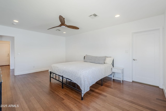 bedroom with recessed lighting, visible vents, baseboards, and wood finished floors