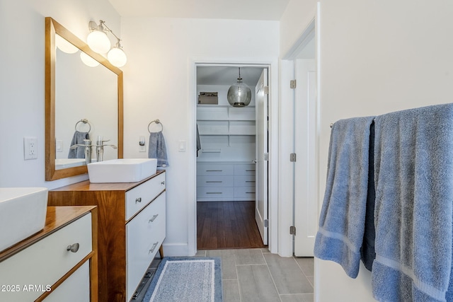 full bathroom with vanity and a walk in closet