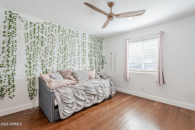 bedroom featuring ceiling fan, baseboards, and wood finished floors