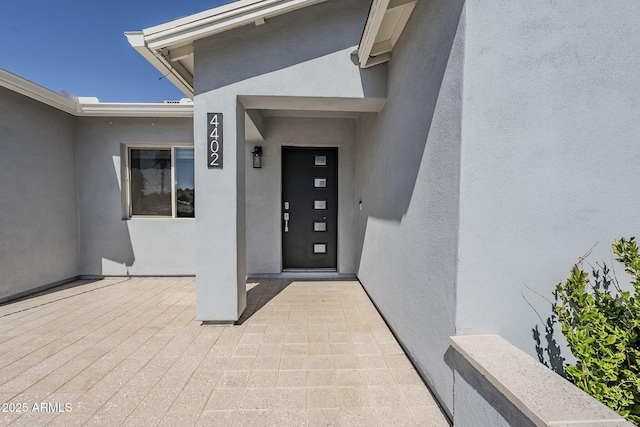 entrance to property featuring stucco siding