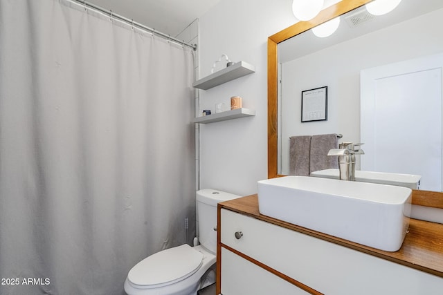 bathroom featuring visible vents, toilet, and vanity