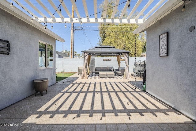 view of patio featuring a gazebo, outdoor lounge area, and fence