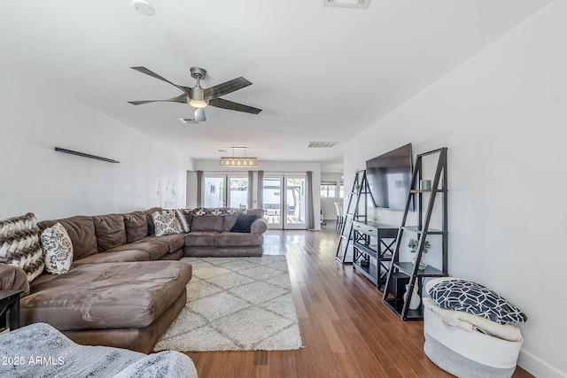 living room featuring wood finished floors, visible vents, and ceiling fan