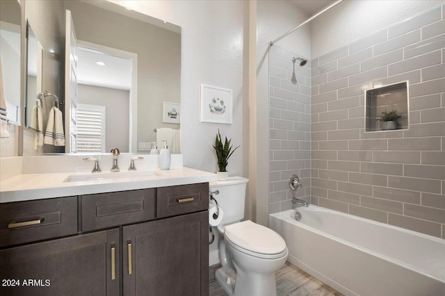 full bathroom with vanity, toilet, hardwood / wood-style floors, and tiled shower / bath combo