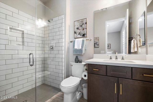 bathroom with vanity, a shower with shower door, and toilet