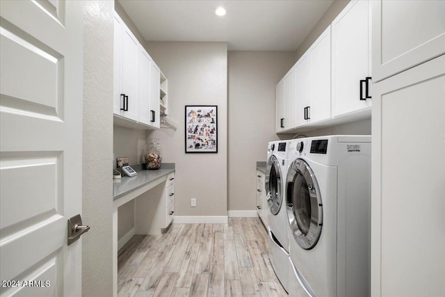 laundry room featuring light hardwood / wood-style floors, cabinets, and separate washer and dryer