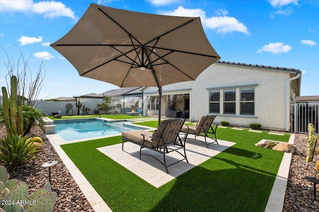 view of swimming pool with cooling unit, a patio, and a lawn