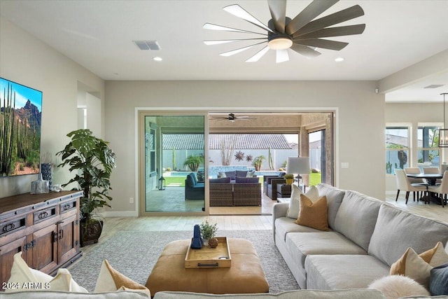 living room with light hardwood / wood-style floors and ceiling fan