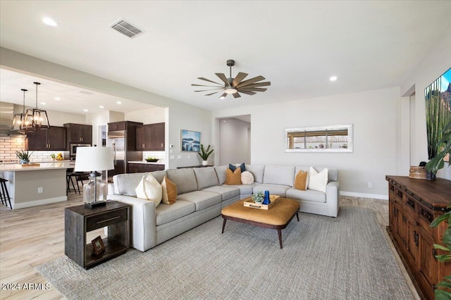 living room featuring light hardwood / wood-style floors and ceiling fan