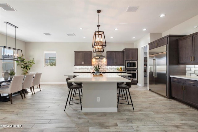 kitchen featuring dark brown cabinets, built in appliances, and a kitchen island