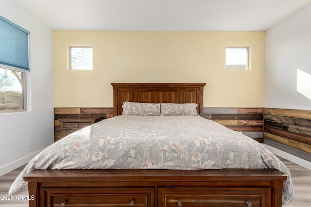 bedroom with multiple windows and light hardwood / wood-style flooring