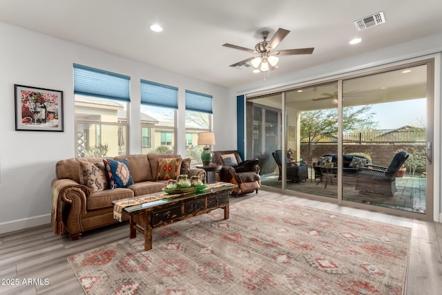 living room with ceiling fan, a healthy amount of sunlight, and light wood-type flooring