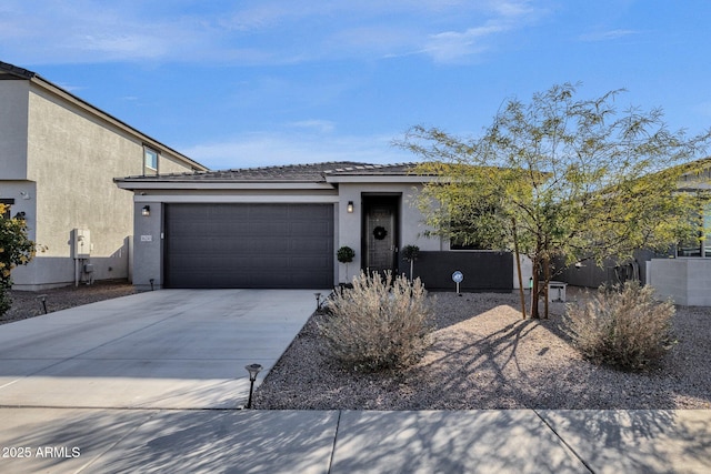 view of front facade with driveway, a garage, and stucco siding