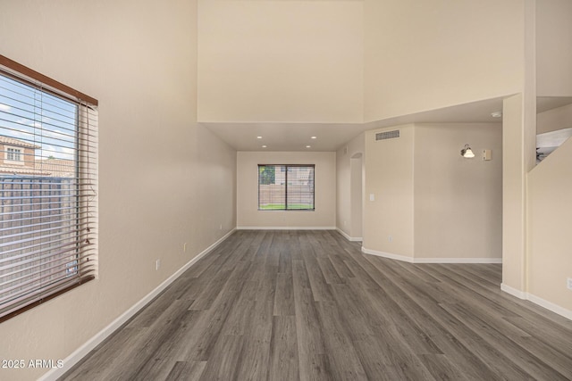 1655 W Stanford Ave, Gilbert, AZ 85233 - unfurnished living room with wood finished floors, a high ceiling, and baseboards