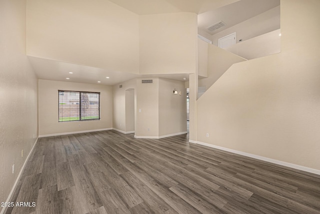 1655 W Stanford Ave, Gilbert, AZ 85233 - unfurnished living room with wood finished floors, baseboards, a towering ceiling, and recessed lighting