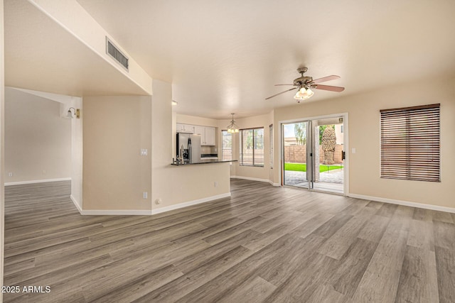 1655 W Stanford Ave, Gilbert, AZ 85233 - unfurnished living room featuring baseboards, ceiling fan, and wood finished floors