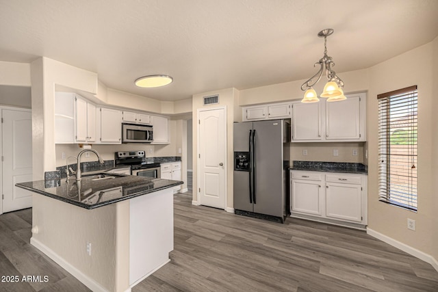 1655 W Stanford Ave, Gilbert, AZ 85233 - kitchen with appliances with stainless steel finishes, a sink, dark wood-style floors, a peninsula, and white cabinets