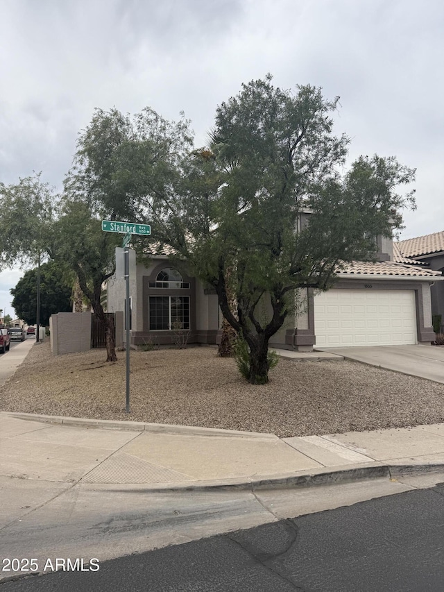 1655 W Stanford Ave, Gilbert, AZ 85233 - obstructed view of property featuring a garage, concrete driveway, stucco siding, and a tiled roof