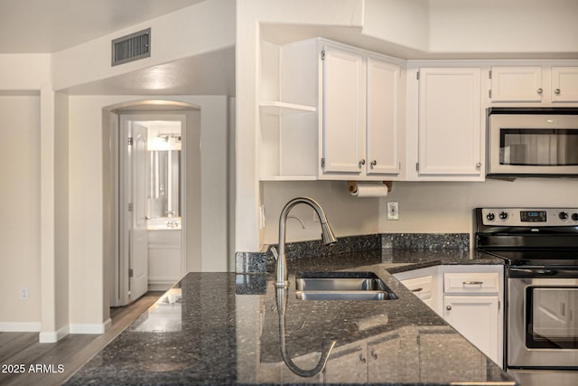 1655 W Stanford Ave, Gilbert, AZ 85233 - kitchen with stainless steel appliances, a sink, open shelves, white cabinets, and arched walkways