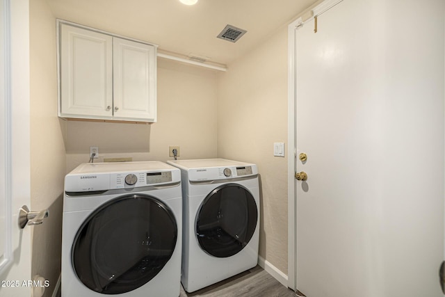 1655 W Stanford Ave, Gilbert, AZ 85233 - laundry area featuring cabinet space, washer and clothes dryer, wood finished floors, and baseboards