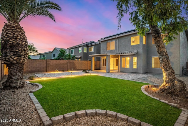 1655 W Stanford Ave, Gilbert, AZ 85233 - back of property at dusk with a patio area, solar panels, and stucco siding