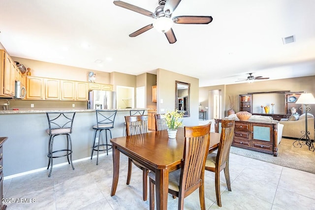 tiled dining room featuring ceiling fan