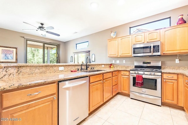 kitchen featuring sink, ceiling fan, light stone countertops, light tile patterned floors, and stainless steel appliances