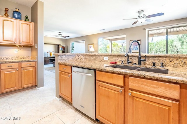 kitchen with dishwasher, light stone counters, plenty of natural light, and sink