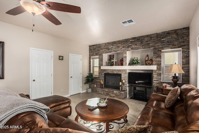 living area featuring ceiling fan, a fireplace, visible vents, and baseboards