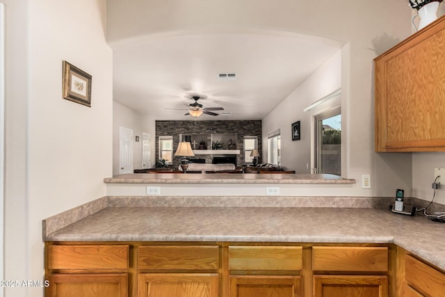 kitchen with open floor plan, arched walkways, visible vents, and a ceiling fan