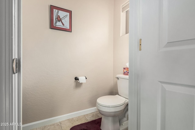 bathroom with tile patterned flooring, toilet, and baseboards