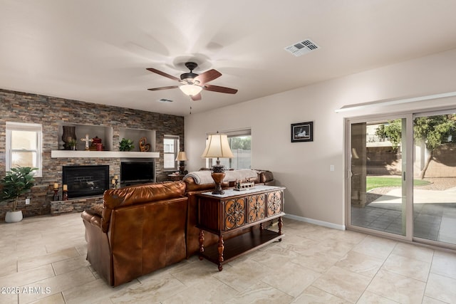 living room featuring baseboards, a fireplace, visible vents, and a ceiling fan