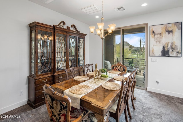 dining room with a chandelier and dark colored carpet