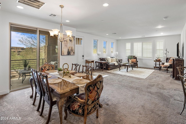 dining area with an inviting chandelier and carpet