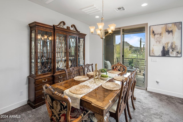 dining area with an inviting chandelier and dark carpet