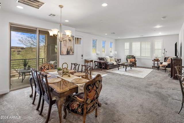 dining area featuring carpet floors and a chandelier