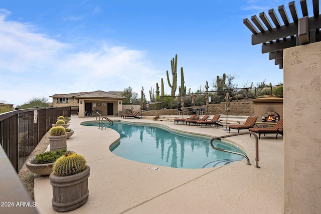 view of pool with an outdoor fireplace and a patio