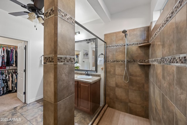 full bathroom with vanity, a ceiling fan, a spacious closet, beam ceiling, and walk in shower