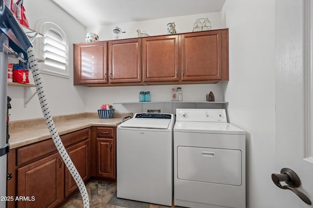 laundry area with washing machine and clothes dryer and cabinet space