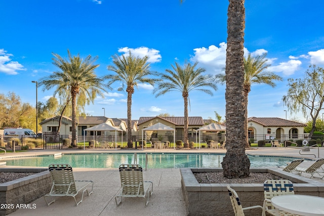 pool with a patio area and fence