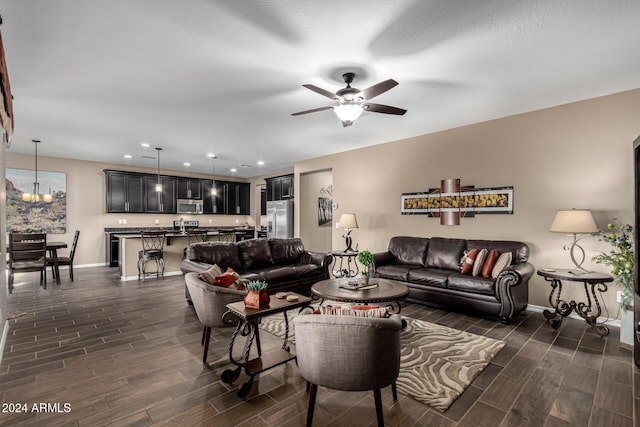 living room featuring ceiling fan with notable chandelier