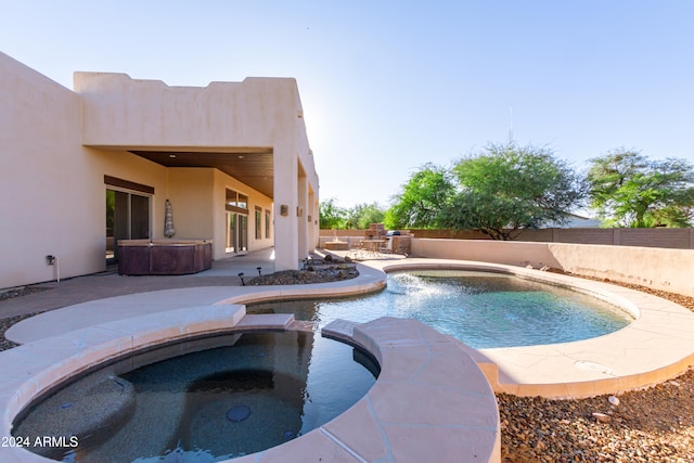 view of pool featuring a patio area and an in ground hot tub