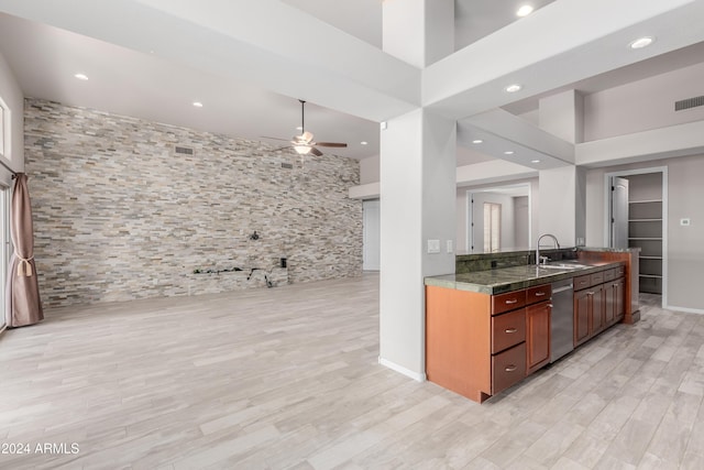 kitchen with ceiling fan, sink, stainless steel dishwasher, a towering ceiling, and light wood-type flooring