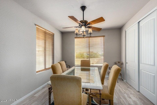 dining area featuring light wood-type flooring, ceiling fan, and a healthy amount of sunlight