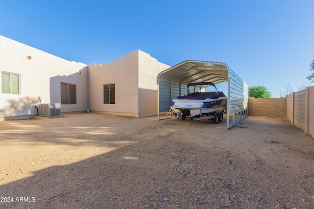 back of property featuring a carport and cooling unit