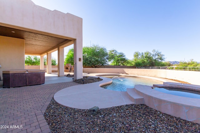 view of pool with pool water feature, a patio area, and an outdoor hot tub